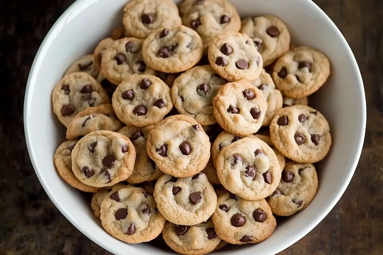 Mini Chocolate Chip Cookies - A large white ceramic bowl filled with freshly baked mini chocolate chip cookies, golden brown with melted chocolate chips