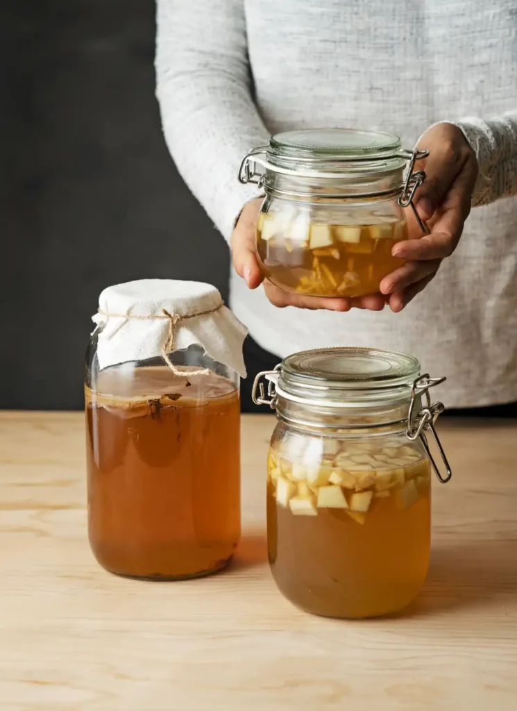 Glass jars filled with chicken broth being prepared for storage.